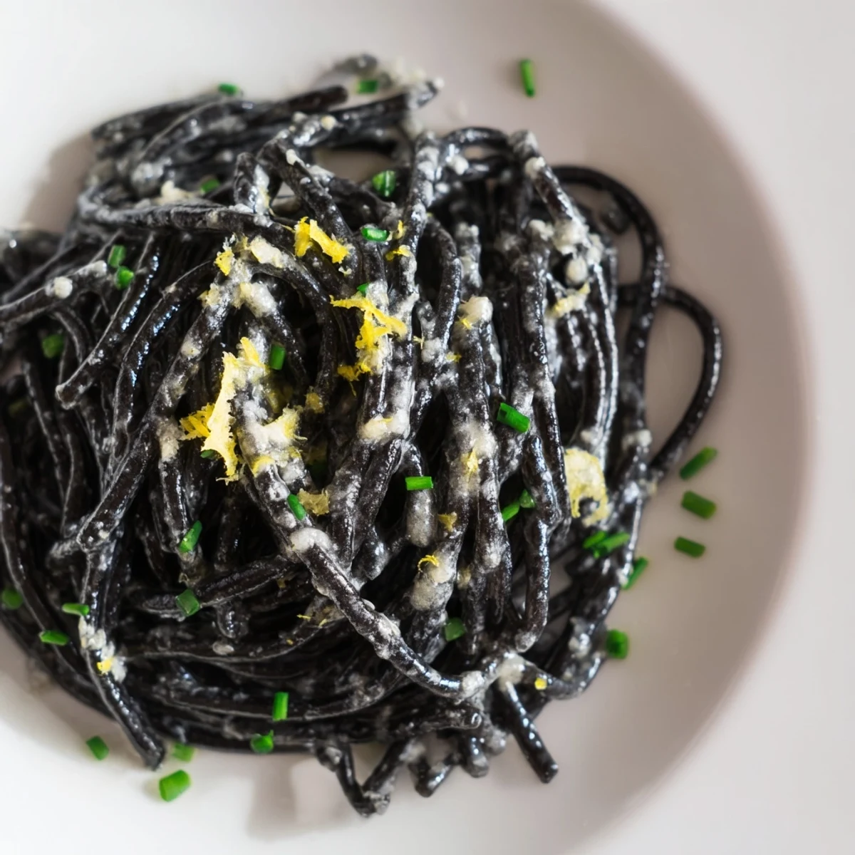 Freshly grated Parmigiano-Reggiano and chives garnish this creamy Squid Ink Pasta.