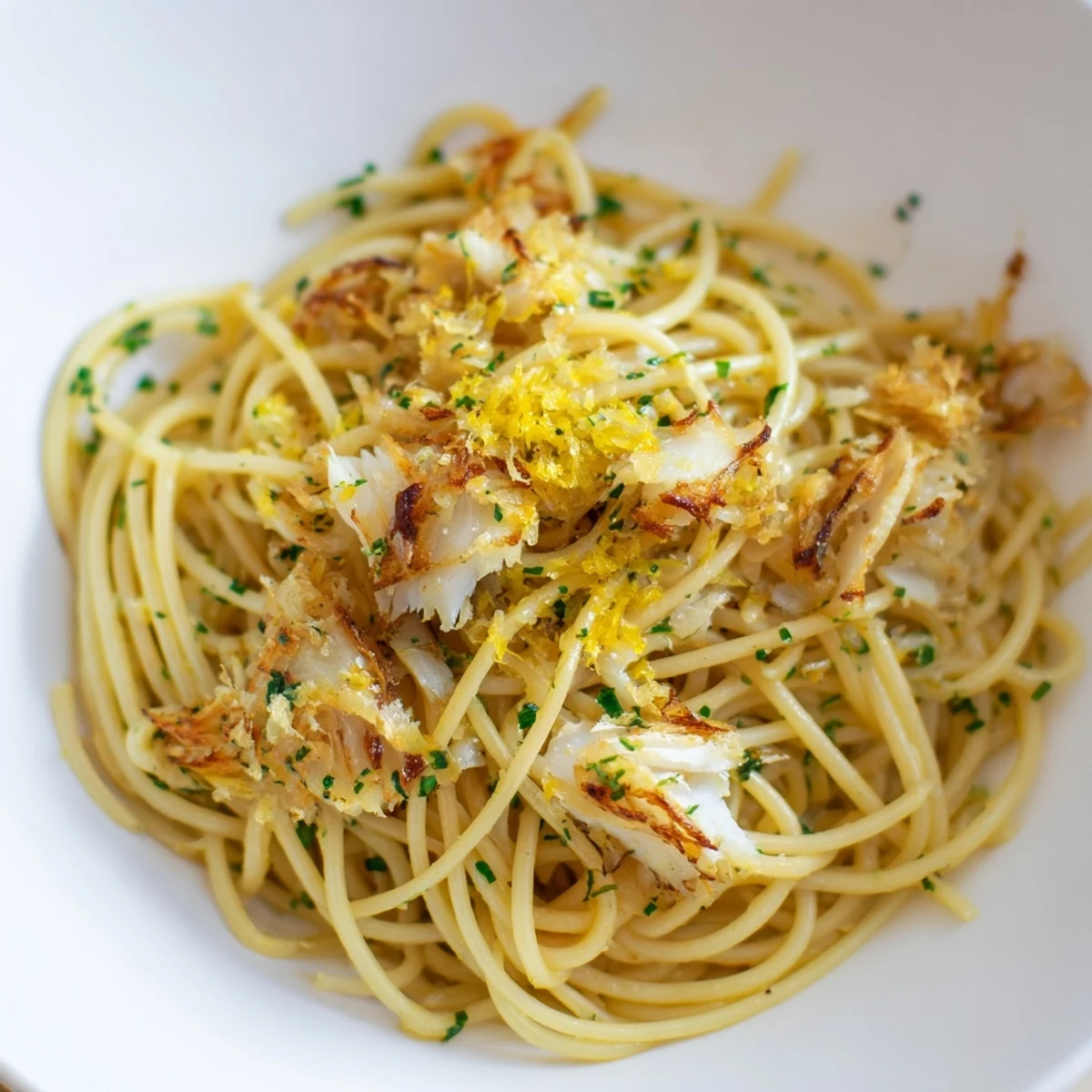 Close-up of a Mediterranean-inspired Crispy Fish Pasta dish, showcasing tender white fish, glossy pasta, and vibrant fresh herbs ready to serve.