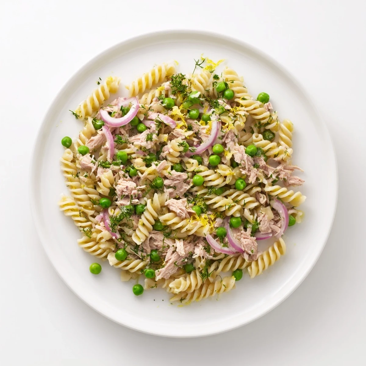 Bright and zesty Lemony Tuna Pasta Salad with peas and herbs served chilled in a white bowl.