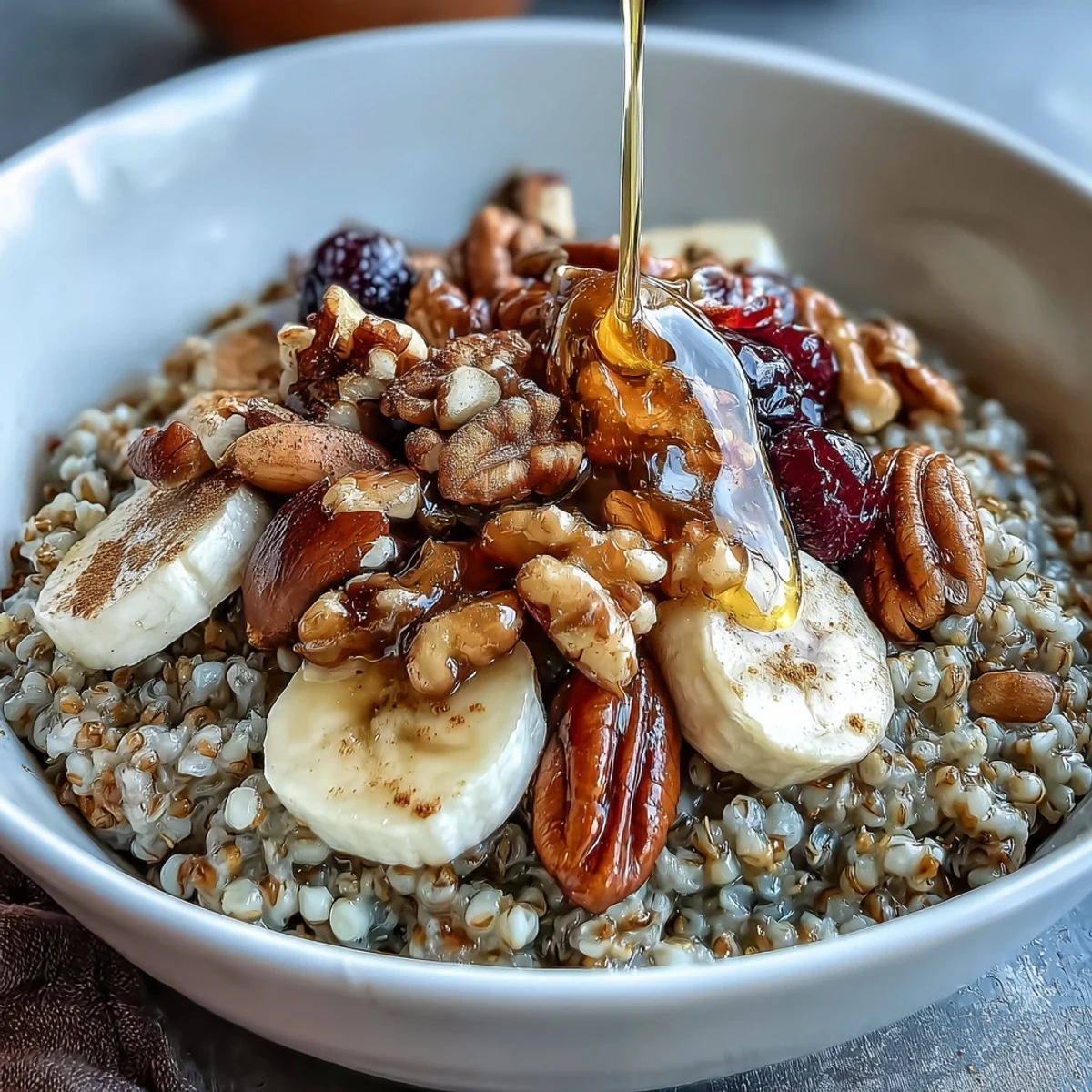 Sunlight shines on fluffy buckwheat groats breakfast bowls garnished with chopped almonds, cinnamon, and juicy strawberries, served alongside a small pitcher of creamy milk.  