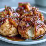 A close-up view of a cut Chīzu Imomochi showcases the soft potato texture and stretchy mozzarella center, ready to be eaten.