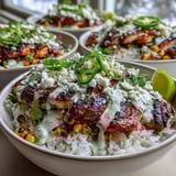 Hearty Street Corn Chicken and Rice Bowls served with juicy lime-marinated chicken thighs, fluffy rice, smoky corn, and a creamy sauce in a vibrant bowl.