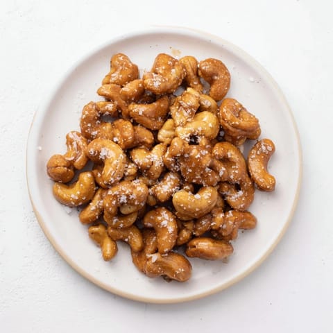 Close-up of freshly baked sweet and salty honey toasted cashews, glistening with honey and salt.