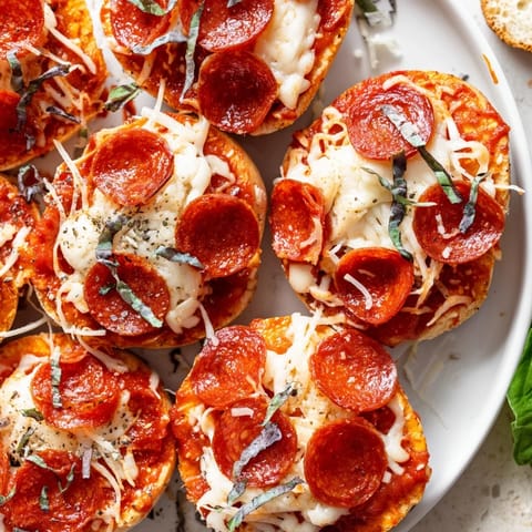 Mini pepperoni pizza bagels just out of the oven, with melting cheese and crispy pepperoni.
