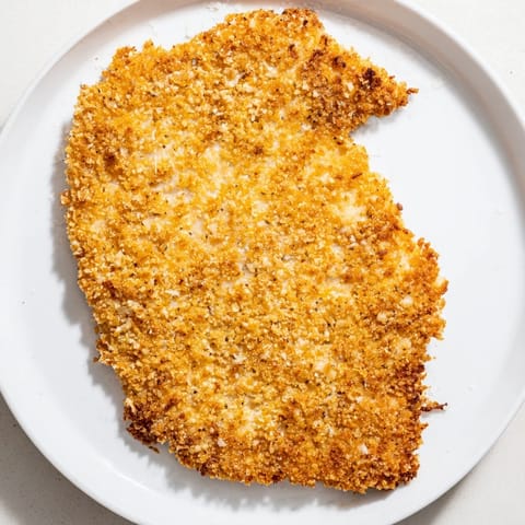 Deliciously breaded Air Fryer Chicken Cutlets, ready to be served with a squeeze of fresh lemon.