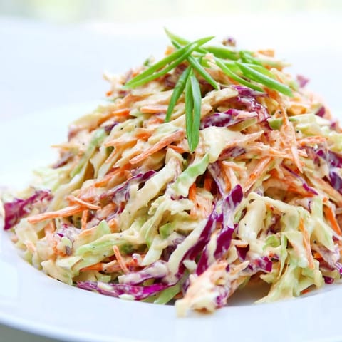 Creamy Quick Coleslaw Salad, featuring shredded cabbage and carrots, ready to serve with a barbecue.