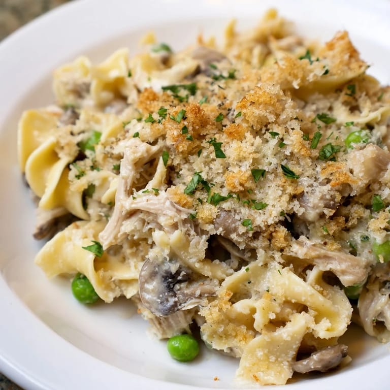 Creamy Tuna Noodle Casserole featuring tender egg noodles mixed with a rich, savory sauce.