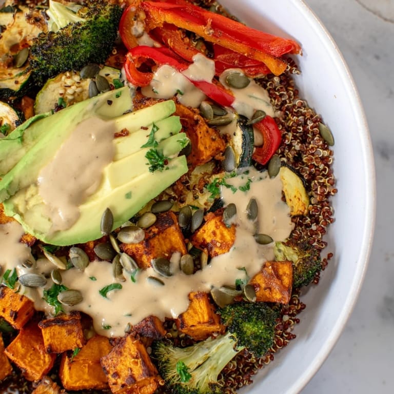 Savory roasted vegetables and protein-packed chickpeas in a wholesome Quinoa Buddha Bowl, served with a drizzle of tahini sauce.