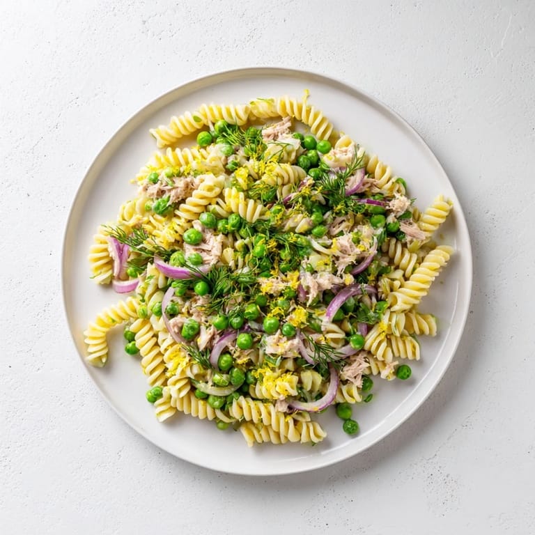Chilled Lemony Tuna Pasta Salad featuring red onion and capers, perfect for a sunny picnic lunch.