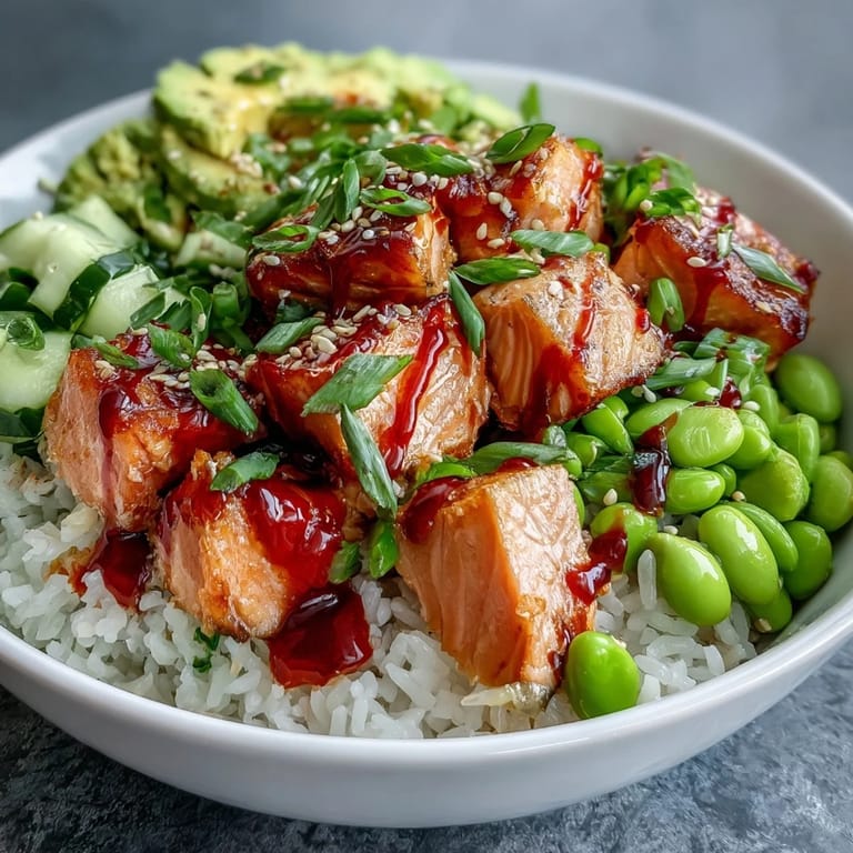 This colorful Salmon Rice Bowl includes crisp cucumber, creamy avocado slices, and a spicy sriracha mayo drizzle.  