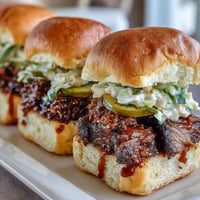 BBQ Baby Shower Brisket Sliders piled high with smoky, tender beef, tangy BBQ sauce, and crunchy coleslaw on soft buns.