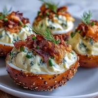 Smoked salmon deviled eggs with everything seasoning, garnished with dill and extra salmon for a flavorful brunch appetizer.