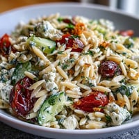 Fresh Mediterranean orzo salad with cucumber, feta, and lemon dressing, bursting with vibrant colors and zesty flavors.  